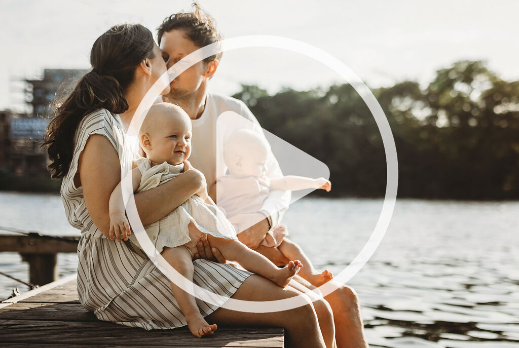 Una familia feliz sentada junto al agua disfrutando del tiempo juntos.