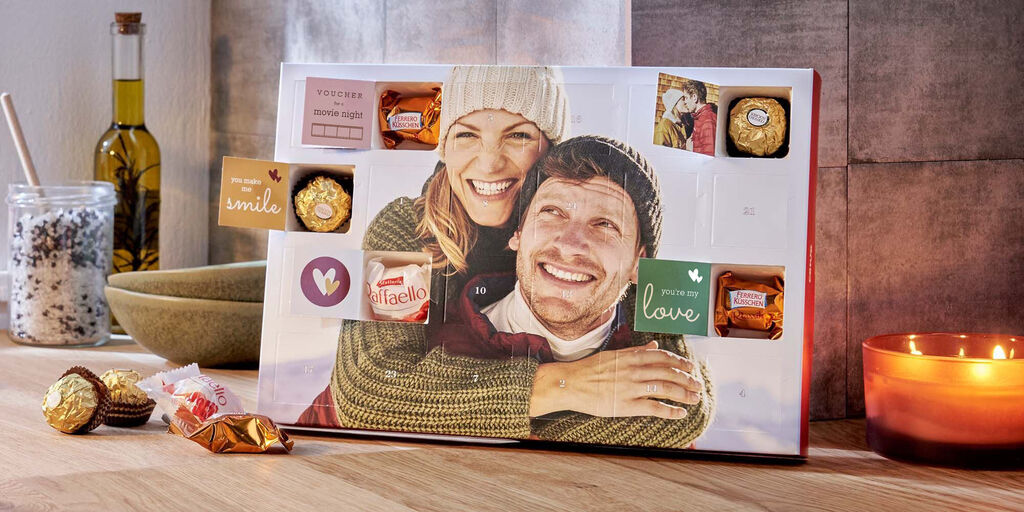 CCalendario de Adviento personalizado con chocolates y notas románticas sobre una mesa.