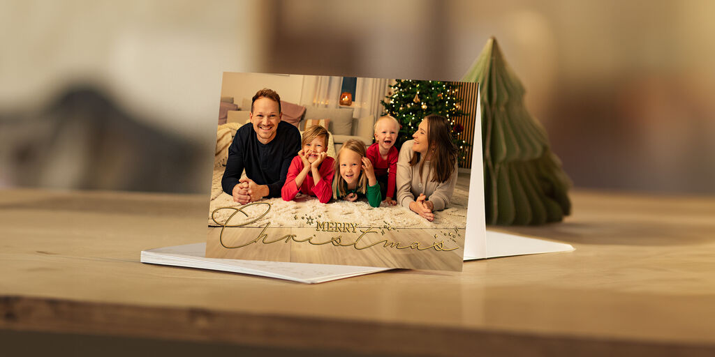 Tarjeta navideña con foto familiar sobre una mesa.