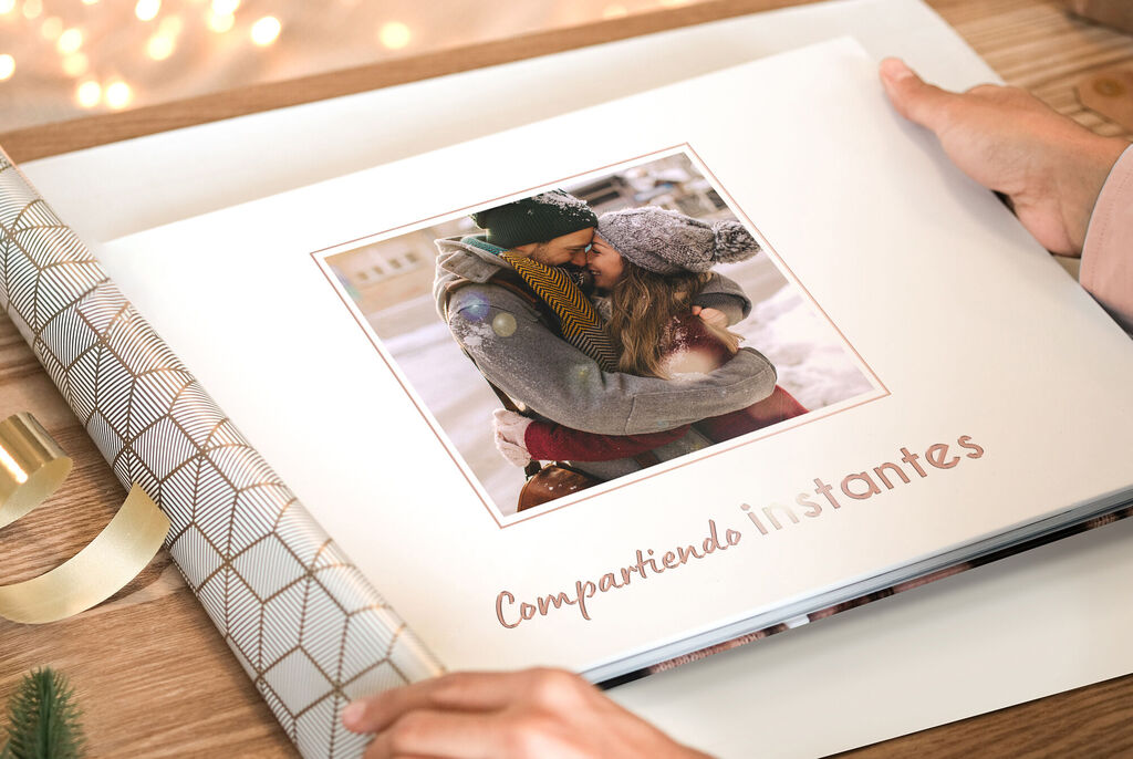 Una persona hojea un álbum de fotos abierto que muestra recuerdos cariñosos.