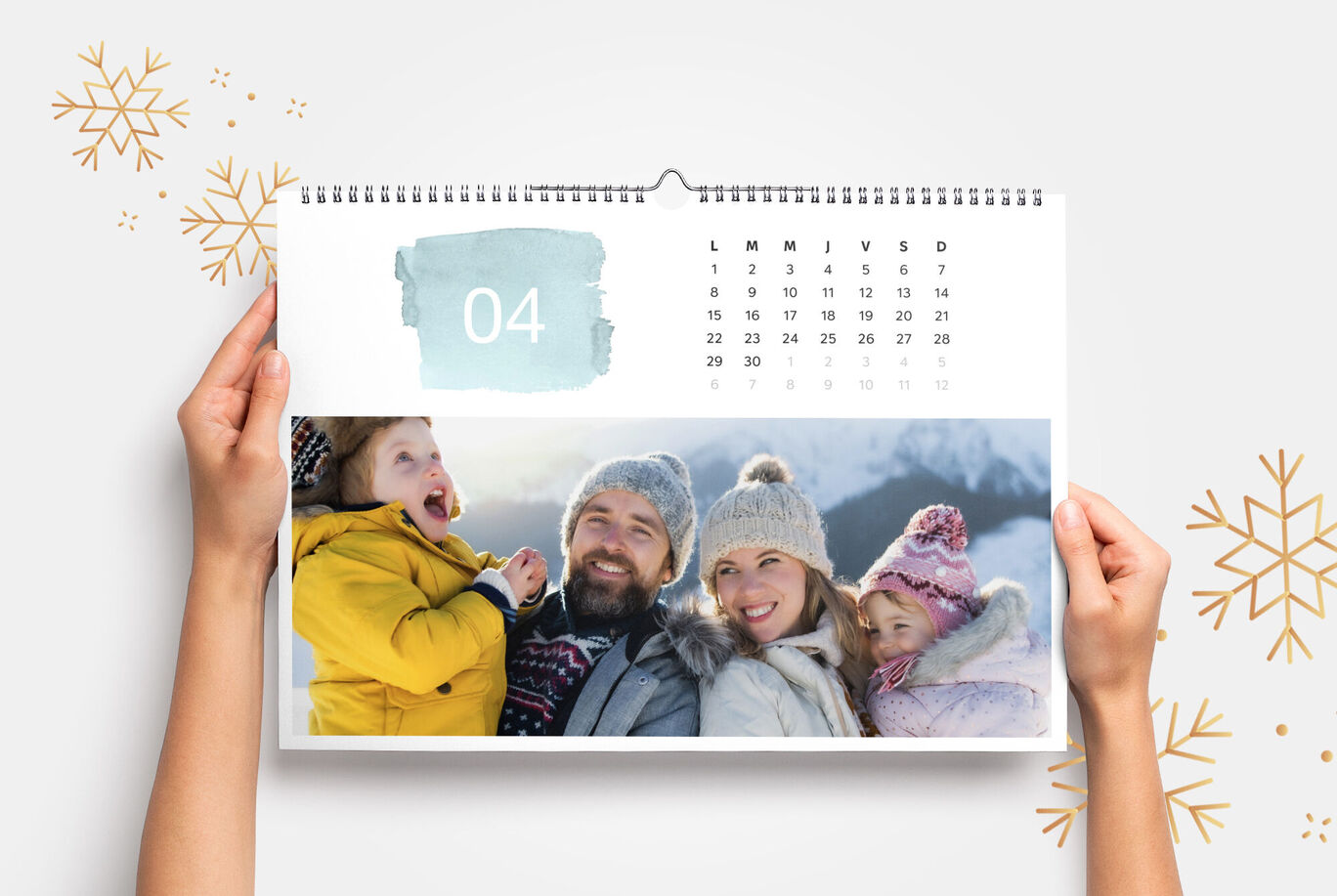 Un calendario sostenido a mano muestra abril con fotos alegres de familiares al aire libre.