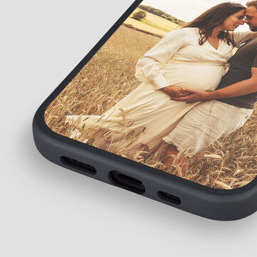 Dos personas posan sonriendo en el campo, una de ellas está embarazada.