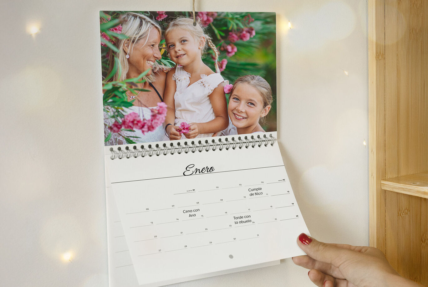 Una persona hojea un calendario mensual con flores rosas en la imagen