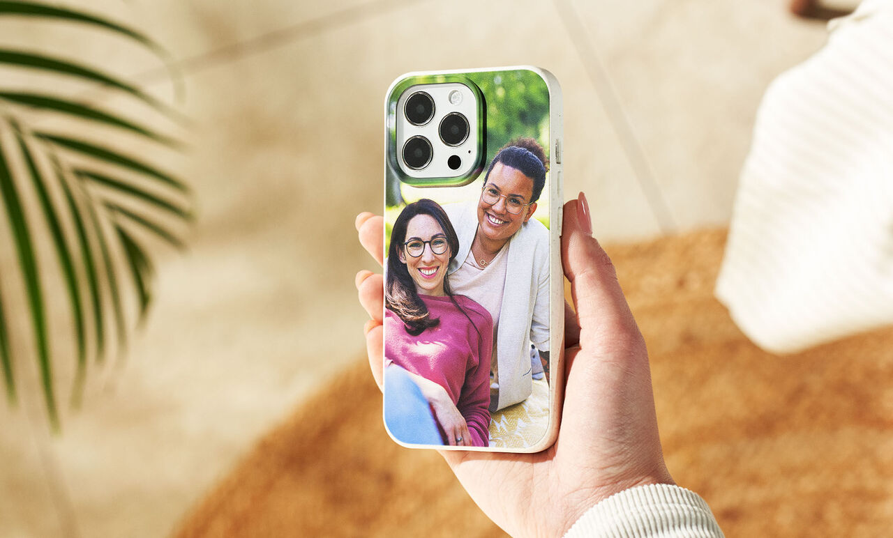 Una mano sostiene un teléfono con una foto personal en la parte de atrás.