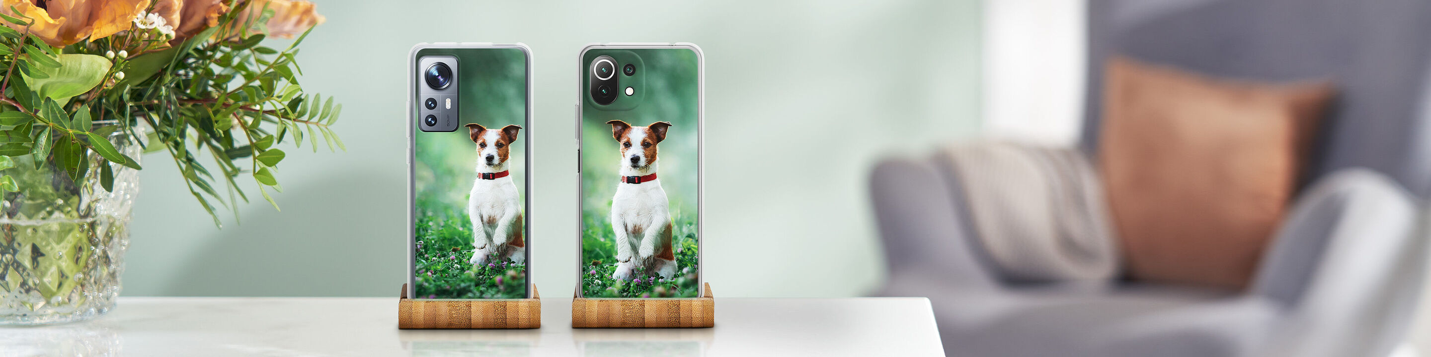 Dos smartphones con motivo de perro sobre una mesa, fondo con plantas.