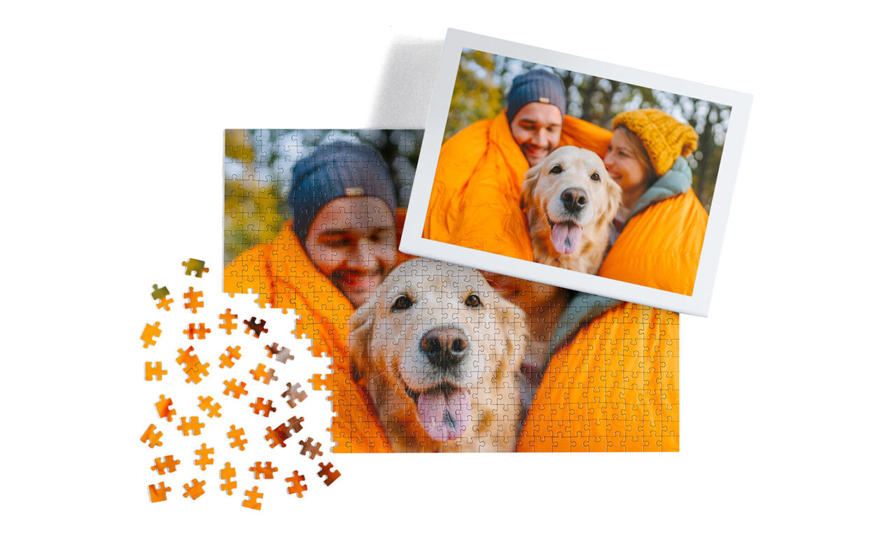 Puzzle personalizado de fotos familiares con una imagen de una pareja y su perro en una manta naranja, junto a su caja de embalaje.