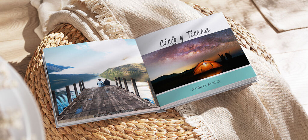 Una página abierta de un libro de fotos CEWE con fotos de paisajes y una tienda al atardecer.