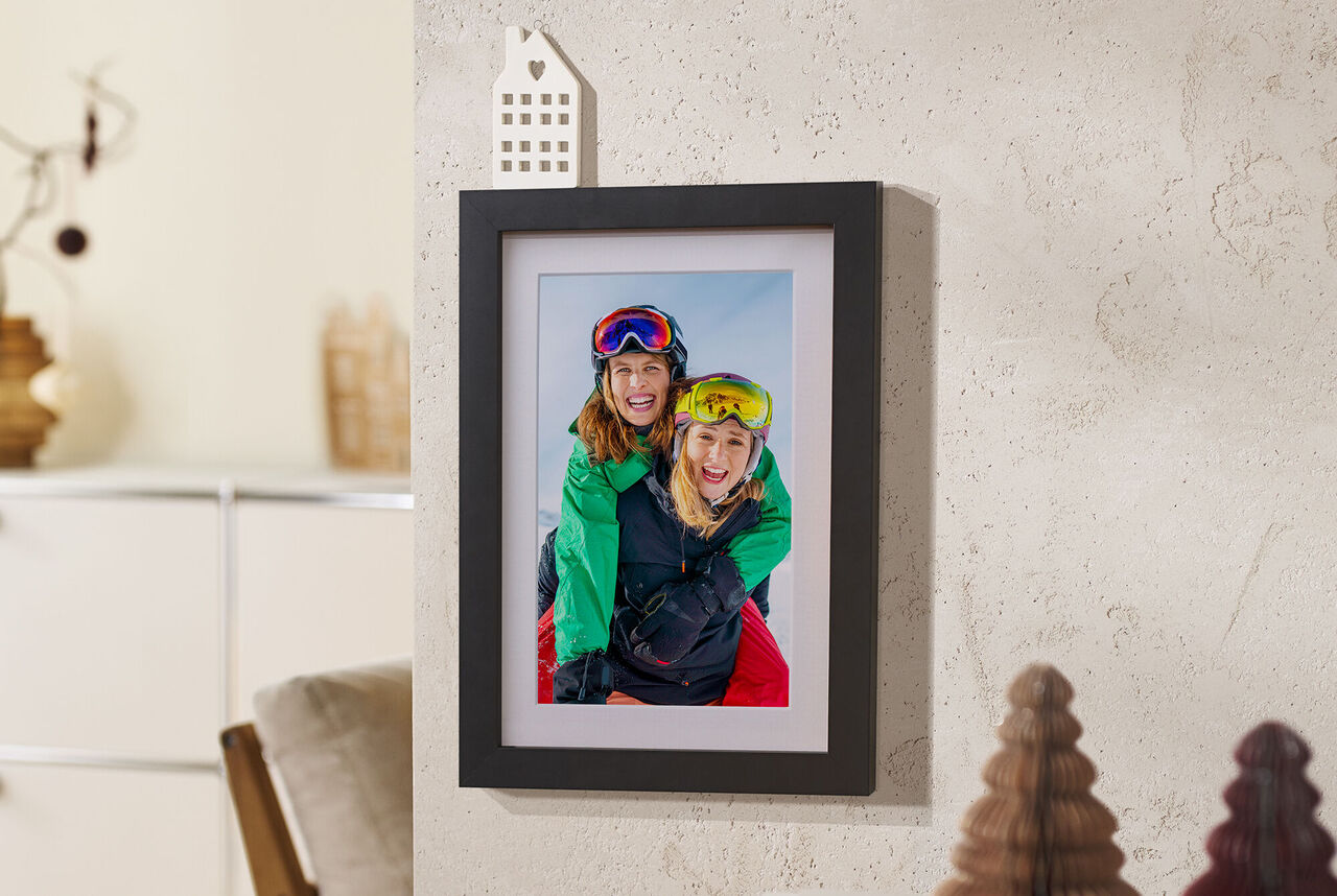 foto enmarcada en la pared con marco de madera negro.