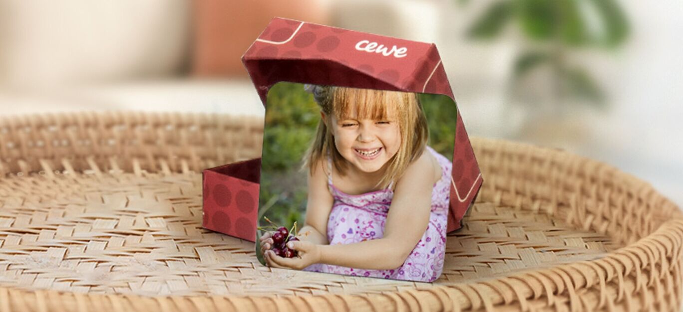 imanes personalizados con fotos y una caja de almacenamiento. Se ve una foto de una niña riendo en el parque como ejemplo.