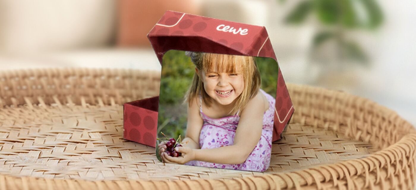 imanes personalizados con fotos y una caja de almacenamiento. Se ve una foto de una niña riendo en el parque como ejemplo.