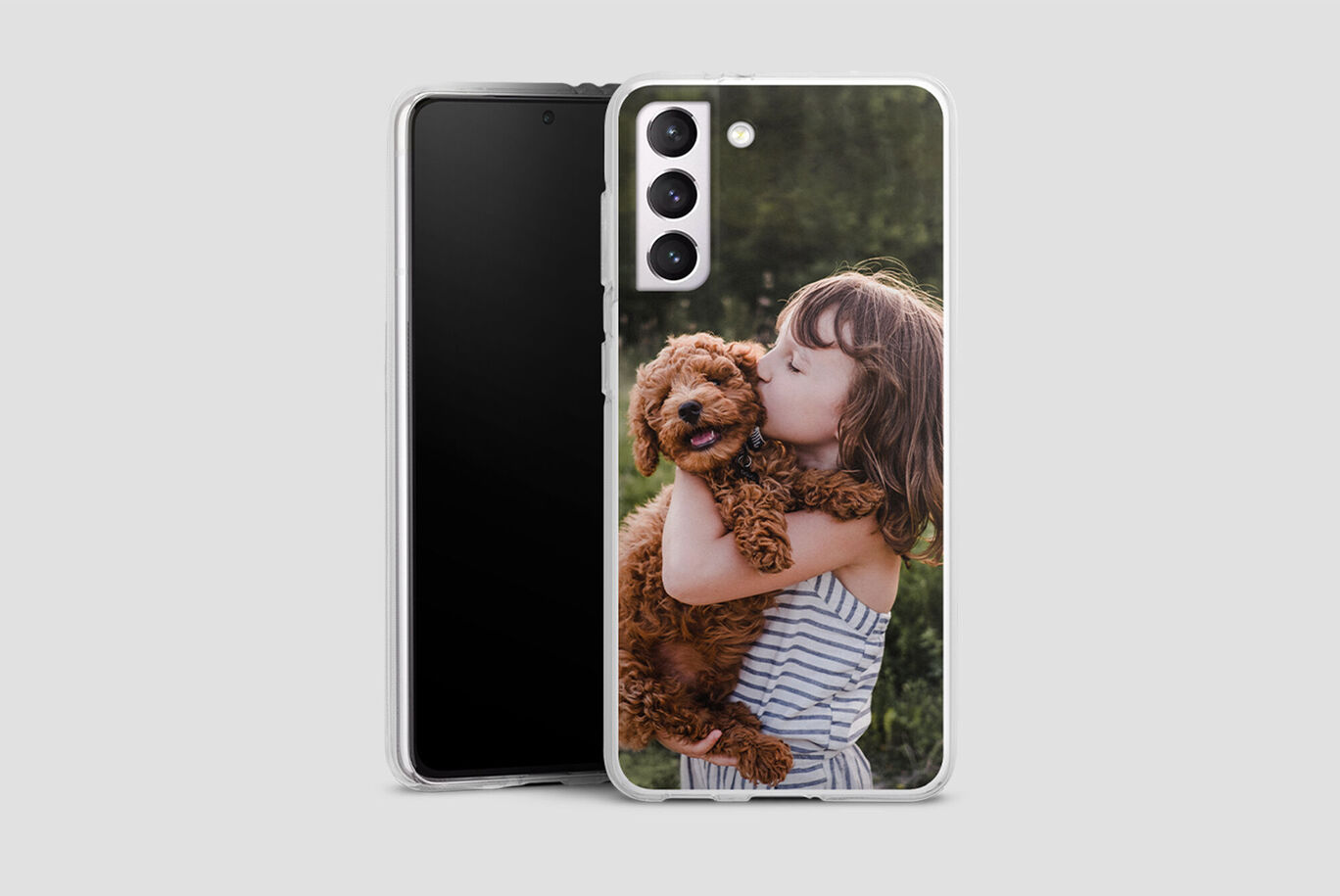 Una niña sostiene un perro marrón en brazos y sonríe feliz.