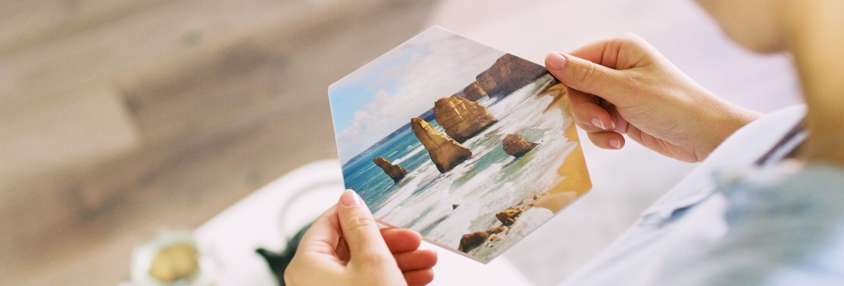 Una persona sostiene una imagen con motivos de playa y rocas