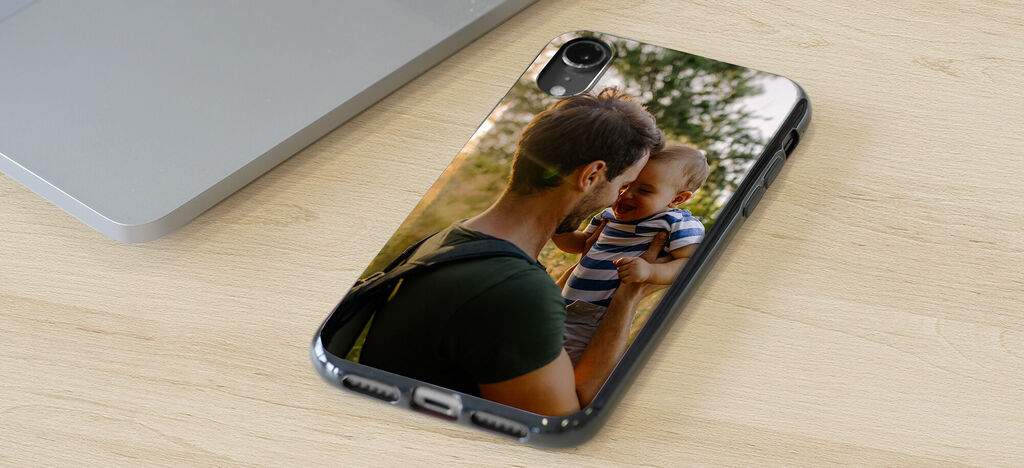 Una persona cariñosa sostiene a un niño, ambos disfrutan de un momento soleado al aire libre.