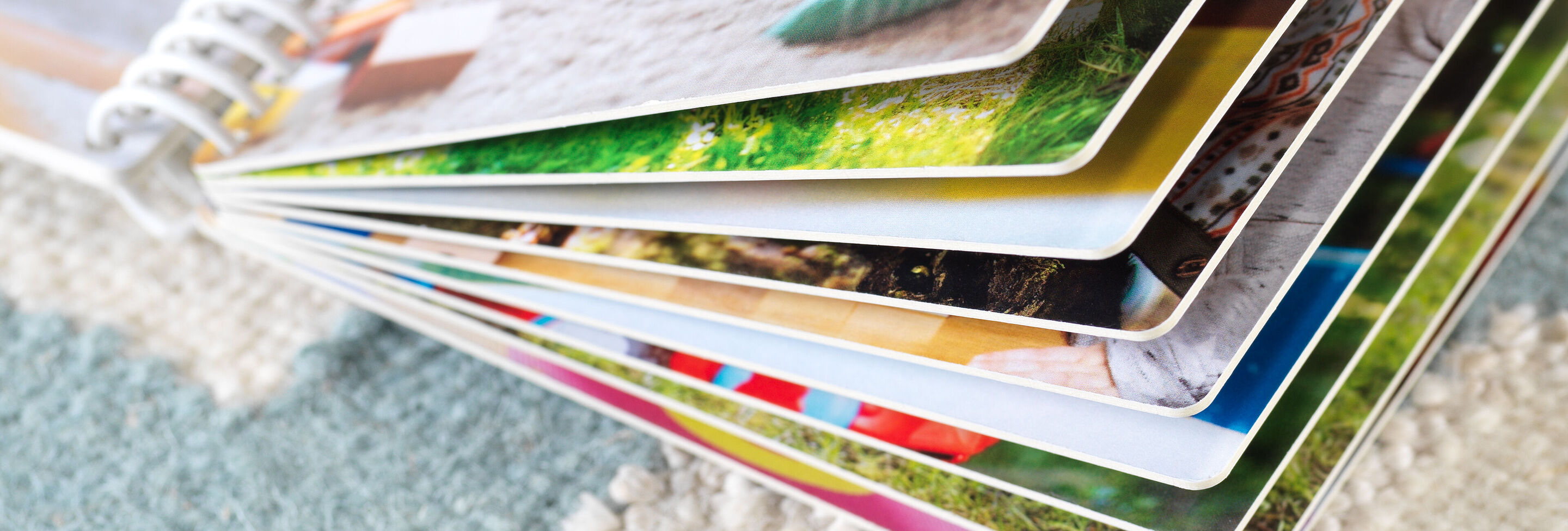 Primer plano de un álbum de fotos CEWE abierto con páginas e imágenes coloridas.