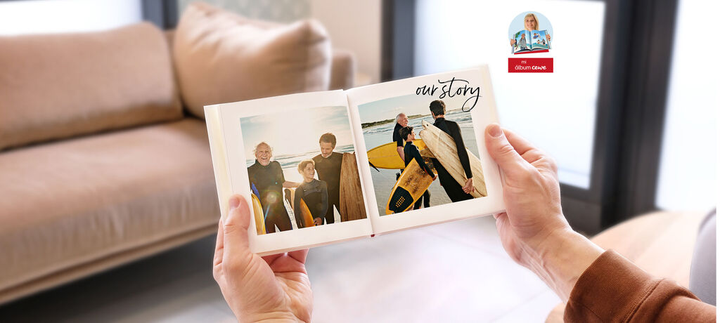 Una mano sostiene un álbum fotográfico abierto con imágenes de una comunidad de surfistas en la playa. Muestra una atmósfera amigable y recuerdos hermosos.