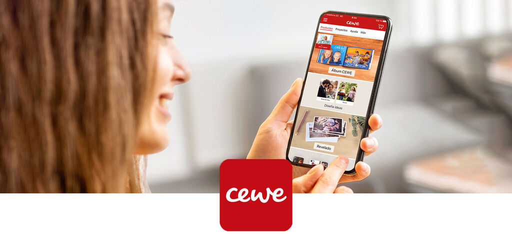 Una persona sostiene un smartphone con la app CEWE abierta mostrando productos fotográficos creativos.