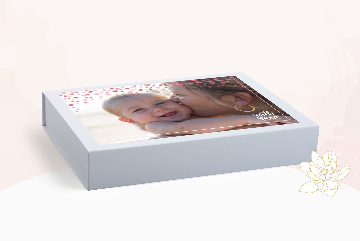 Una madre cariñosa besa a su niño sonriente en la mejilla. La caja tiene un diseño alegre con muchos corazones.