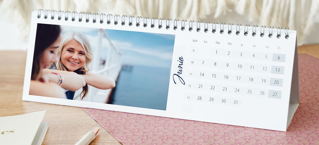 Un calendario fotográfico CEWE diseñado con cariño con una imagen y una hoja de calendario.