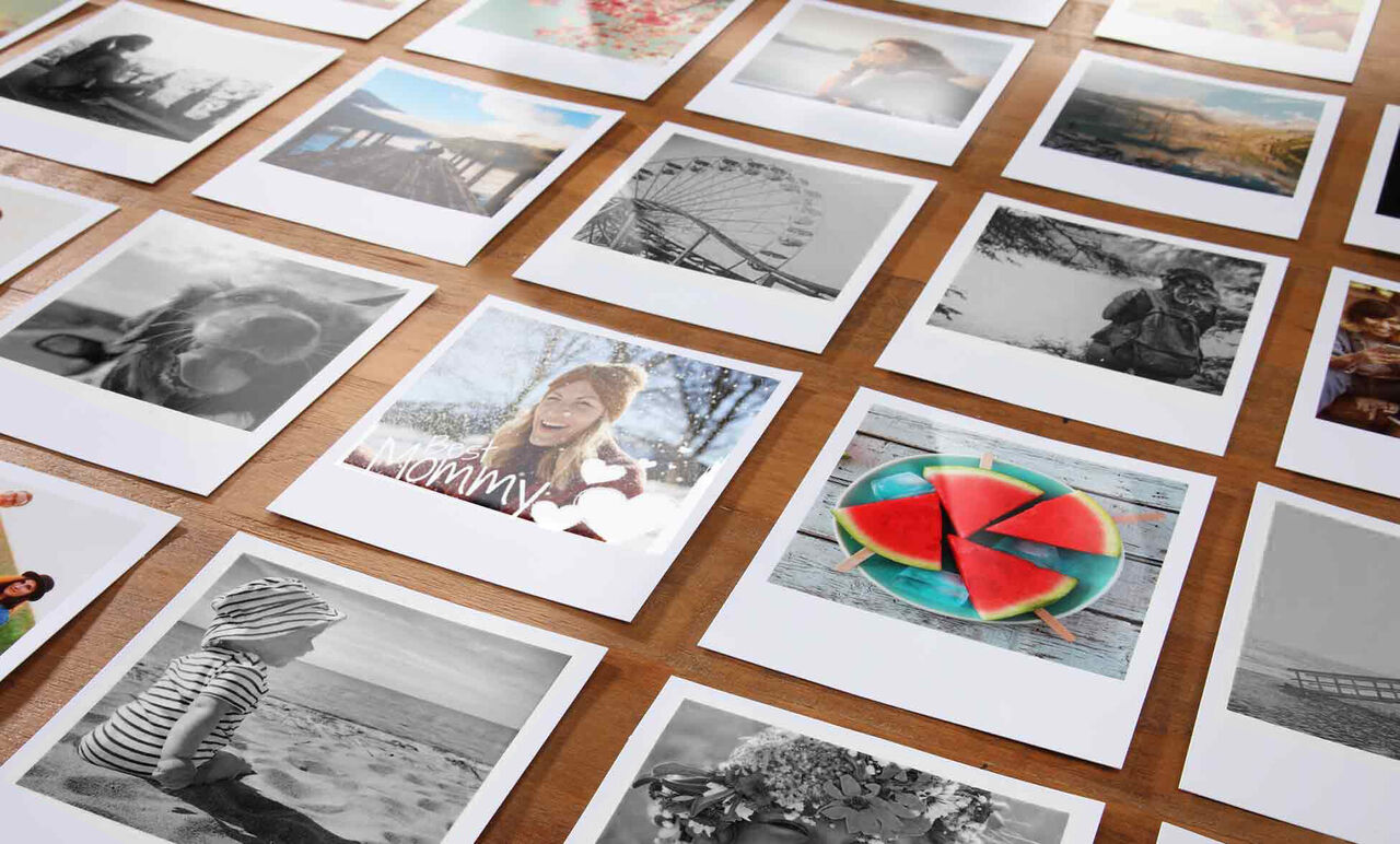 Una selección de impresiones fotográficas coloridas sobre un suelo de madera. Las imágenes muestran momentos felices.