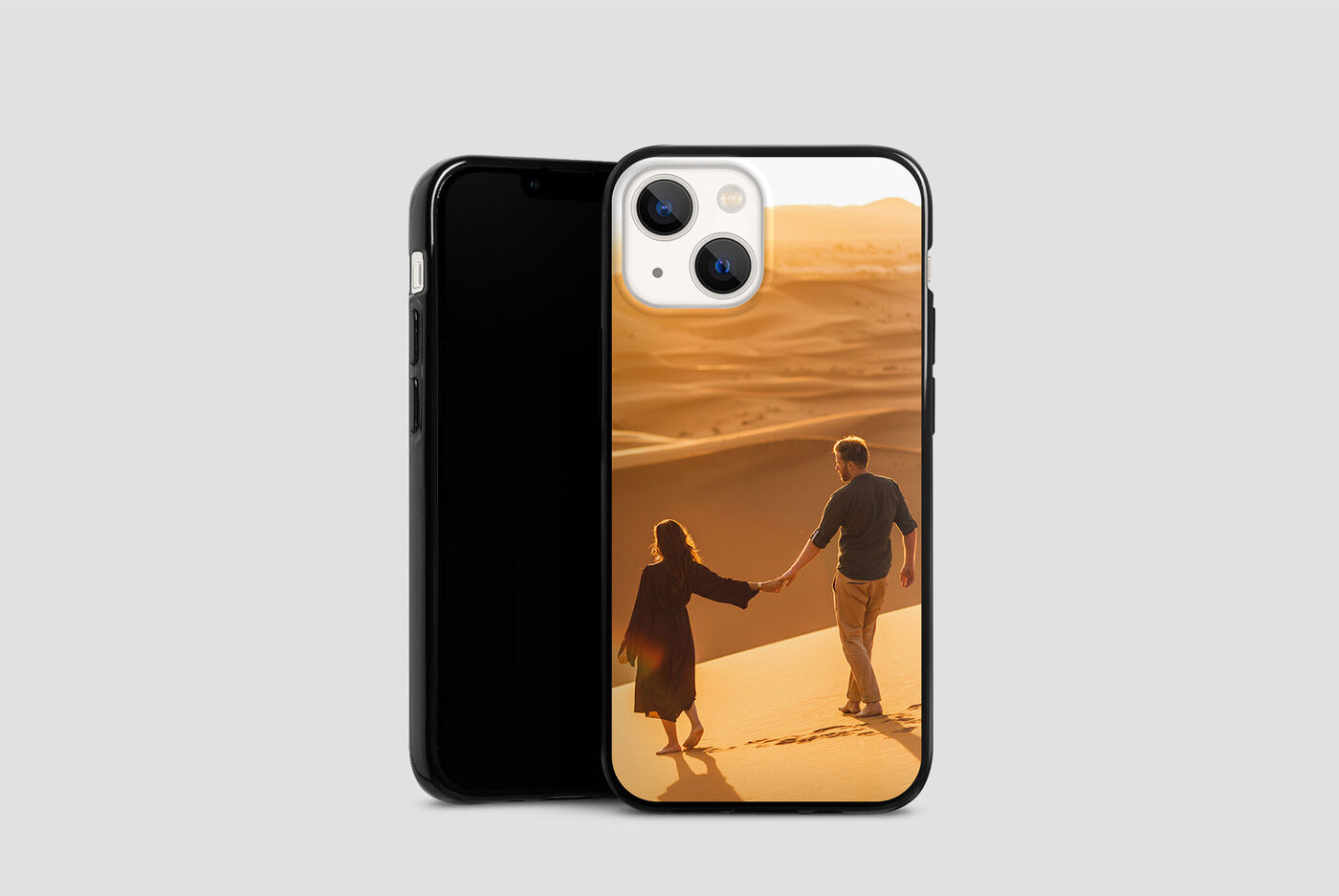 Una pareja toma de la mano y camina por un desierto al atardecer