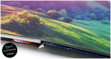 Vista detallada de un álbum de fotos hecho a mano en papel fotográfico de calidad con tonos verdes suaves.