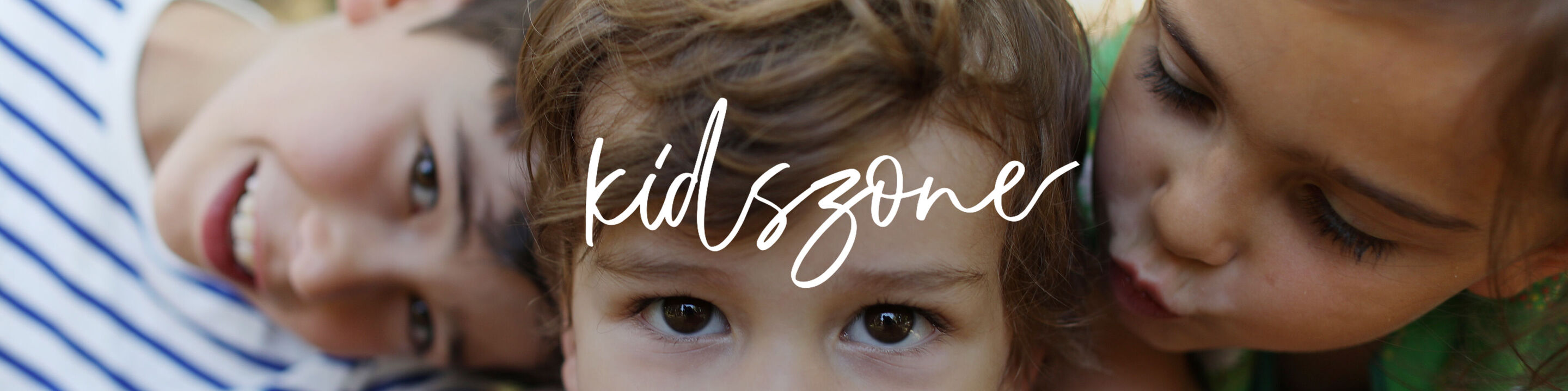 Dos niños y un adulto riendo juntos, disfrutando el tiempo juntos.