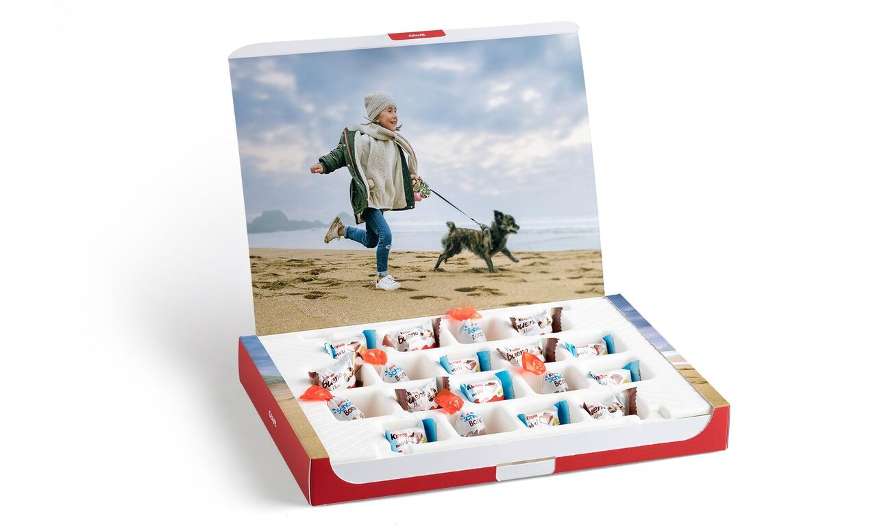 Un niño corre feliz por la playa con un perro. Al fondo hay nubes.