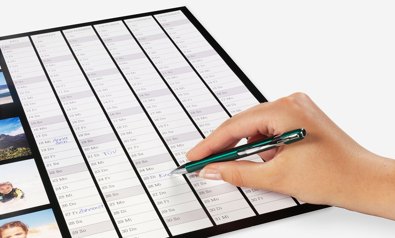 Mano escribiendo en un calendario con un bolígrafo, mostrando un elemento de planificación.