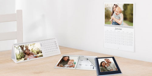 Dos calendarios de fotos individuales con imágenes familiares sobre una mesa.