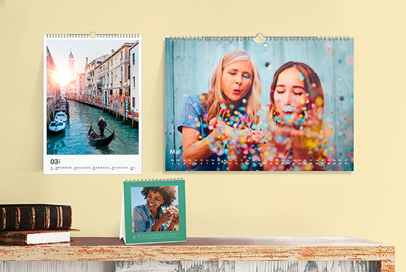 Dos calendarios de pared y un calendario de mesa con fotos en una pared