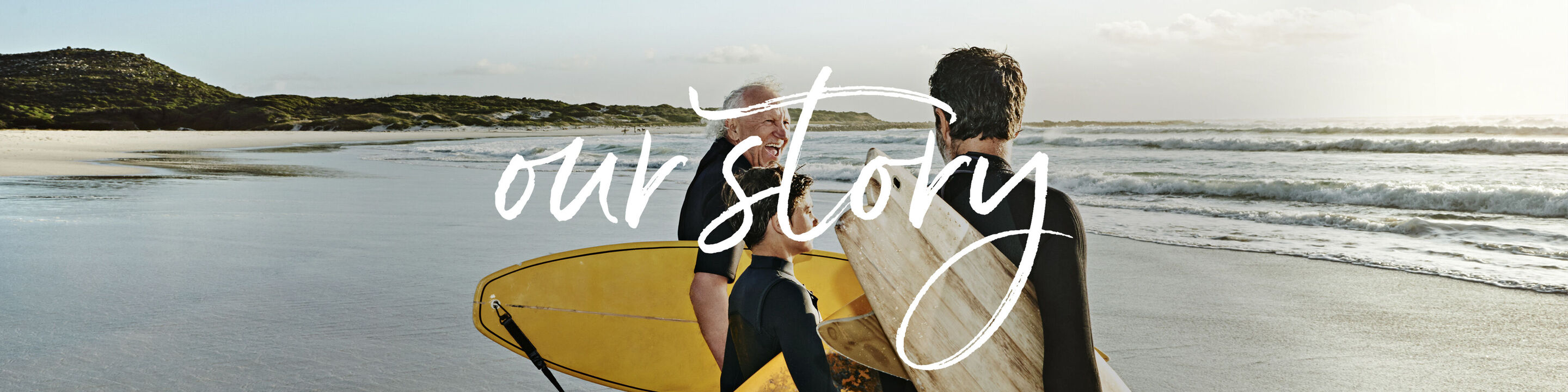 Dos personas con tablas de surf en la playa, el texto 'nuestra historia' aparece sobre la imagen