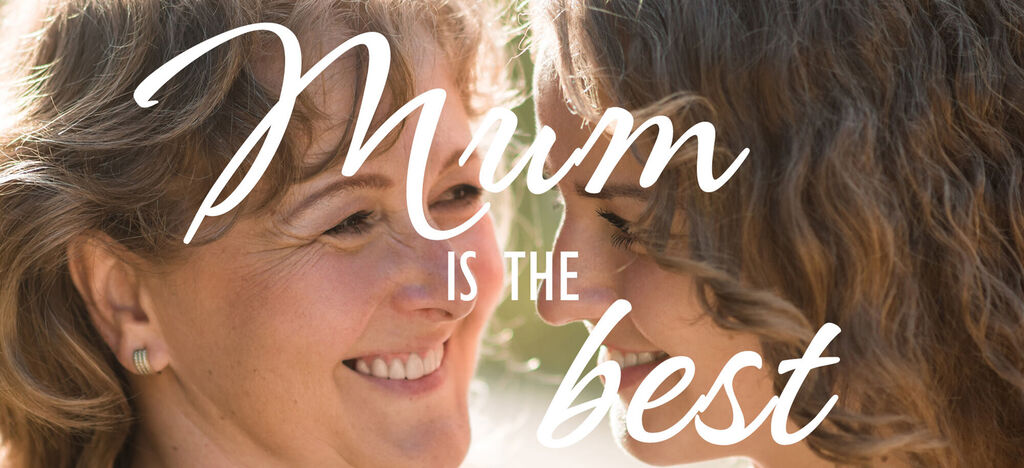 Dos mujeres con cabello rizado se sonríen, rodeadas de naturaleza. Momentos felices.