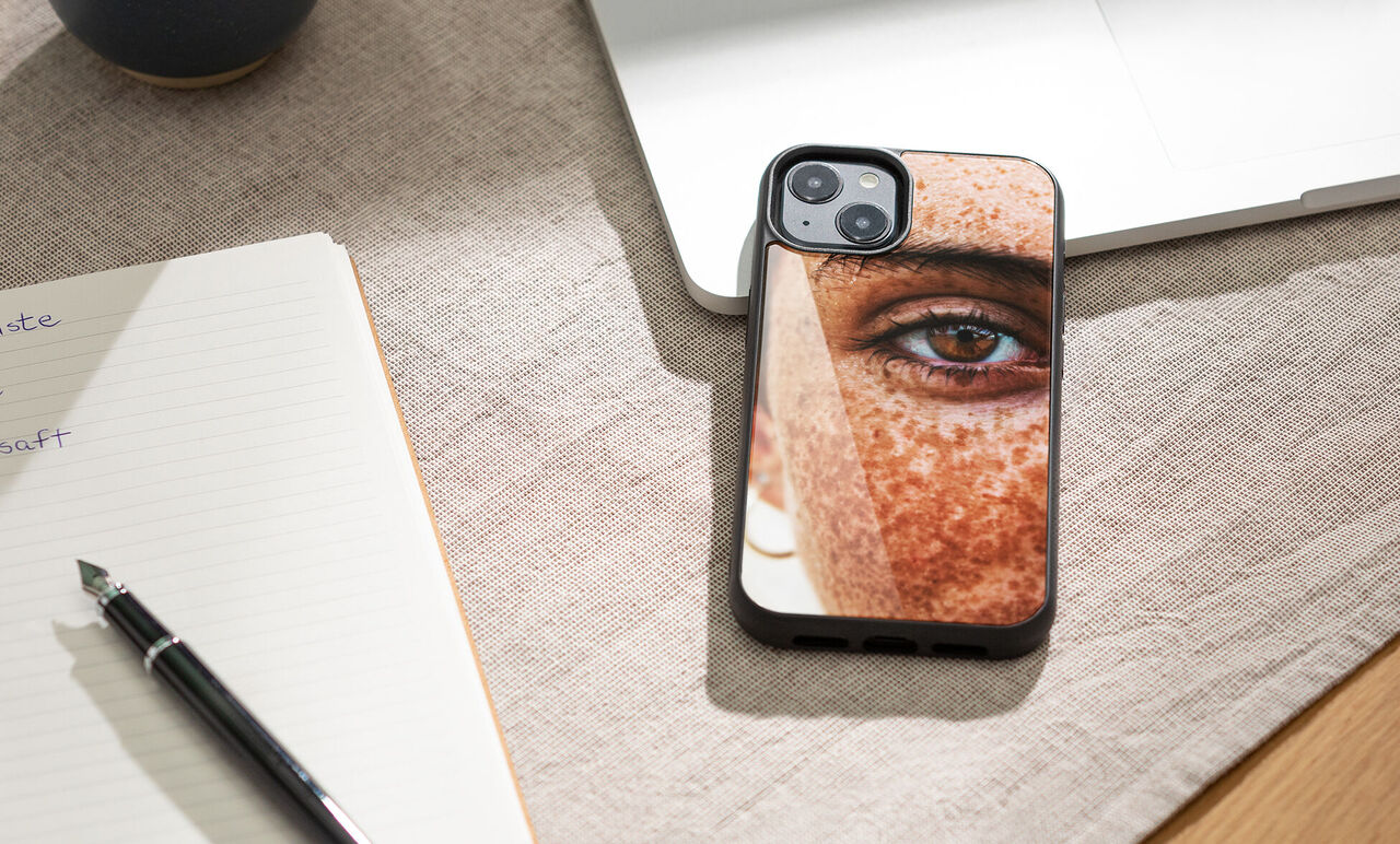 Primer plano de un móvil con una funda personalizada que muestra el rostro de una persona.