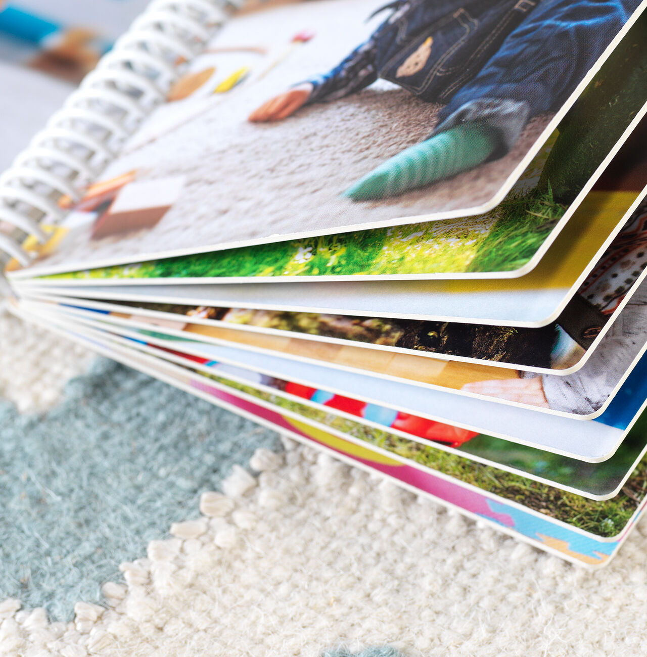 Un hermoso álbum CEWE abierto con imágenes coloridas sobre una alfombra.