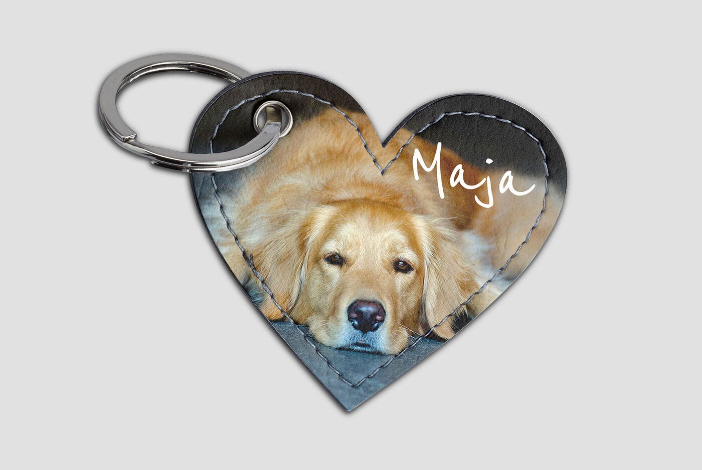 Llaveros en forma de corazón con la imagen de un Golden Retriever, Maja, que está relajada.