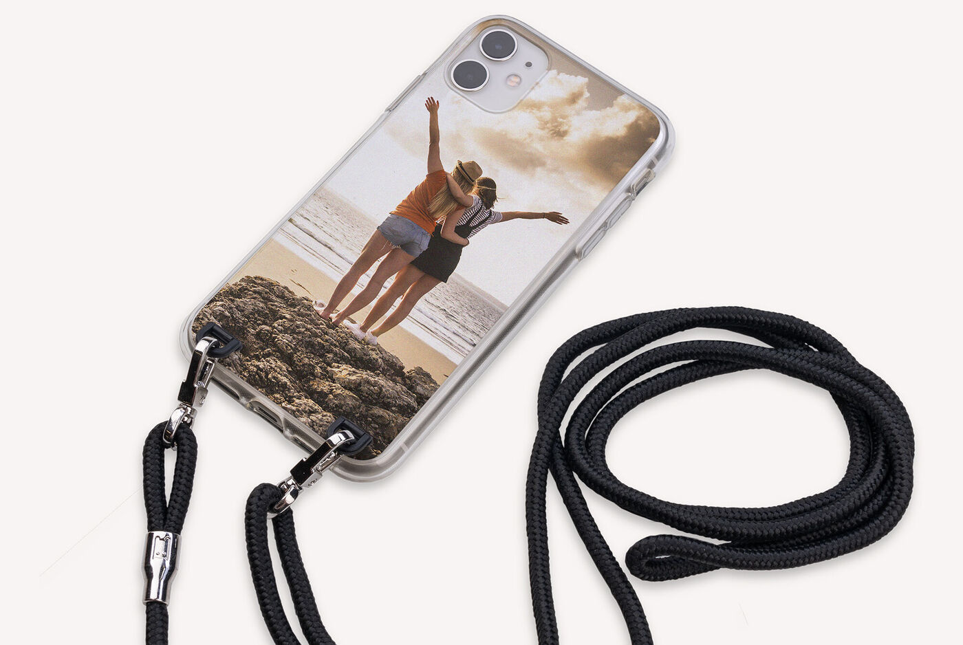 Dos personas disfrutan de un día en la playa con un smartphone en una funda personalizada.