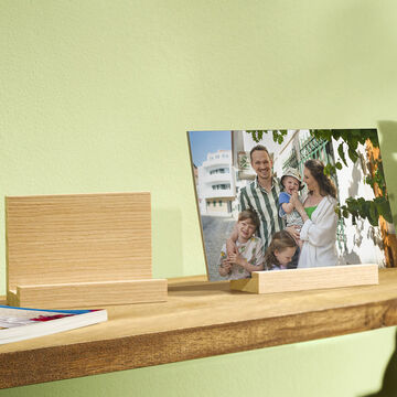 Una estantería de madera con dos fotos enmarcadas que muestran bellos recuerdos.