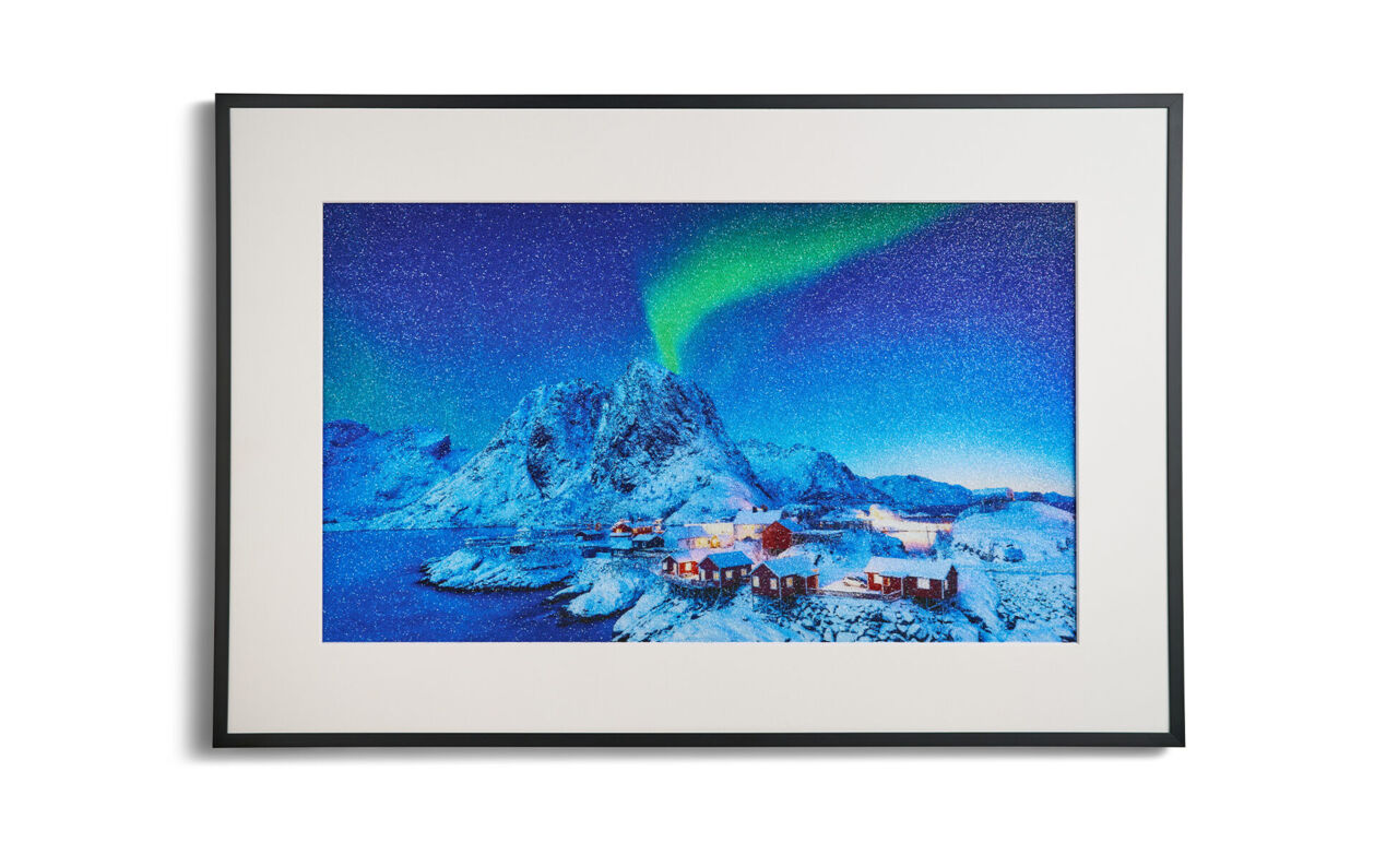 Cuadro mural personalizado CEWE con foto de paisaje de auroras boreales y cristales Swarovski® brillantes en marco negro con passepartout.