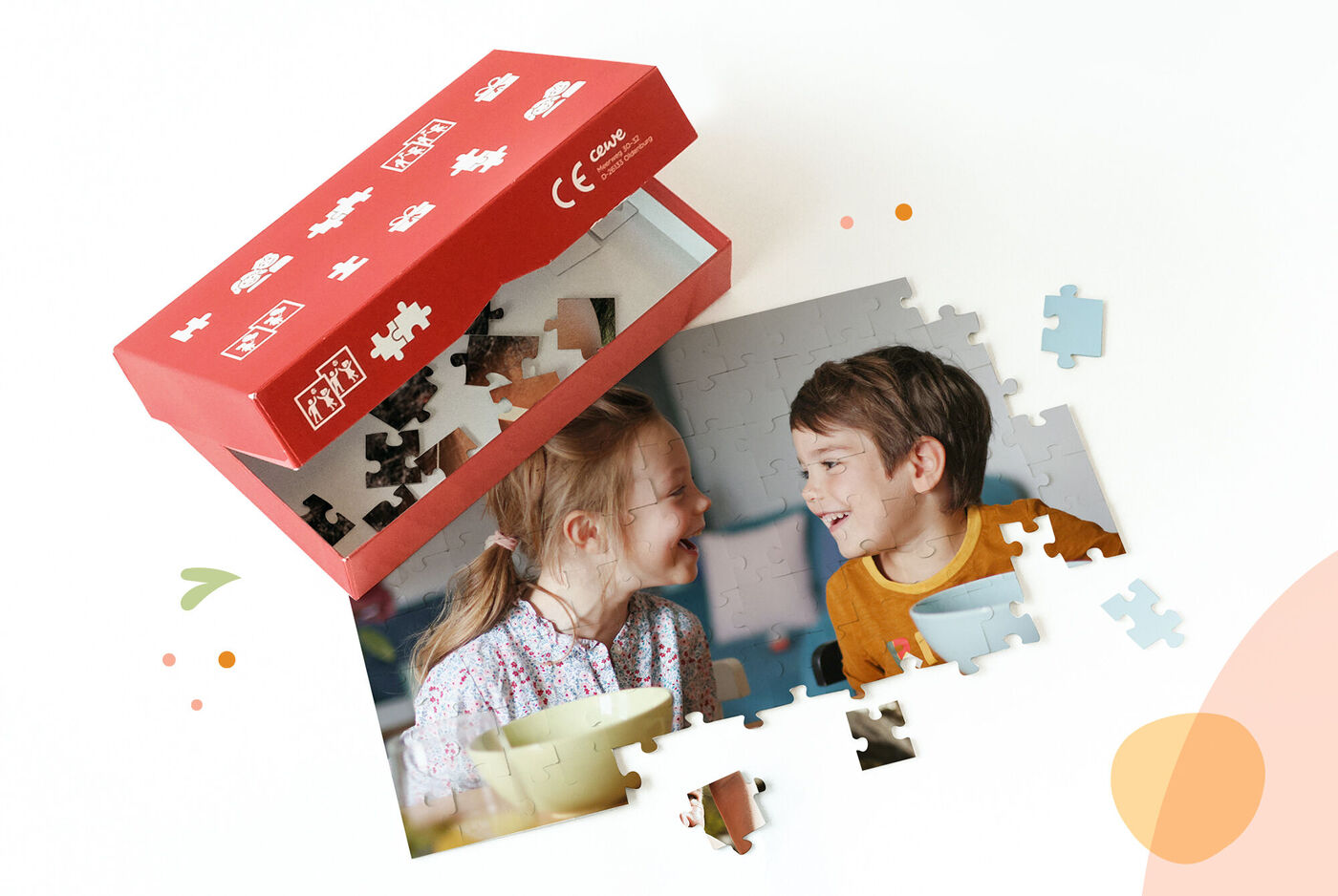 Una caja abierta con piezas de rompecabezas y dos fotos de niños jugando.