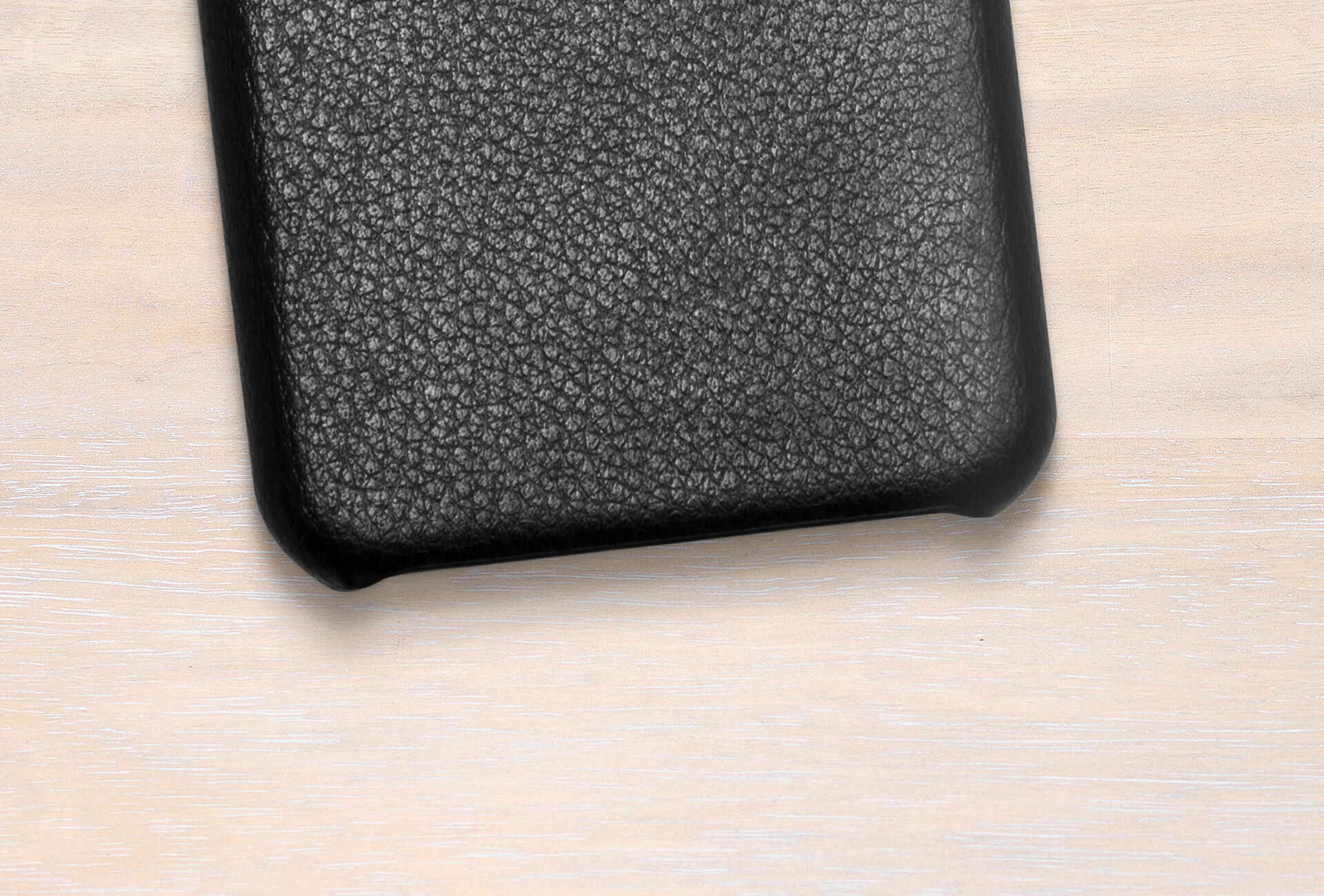 Funda de móvil negra con diseño texturizado sobre fondo claro