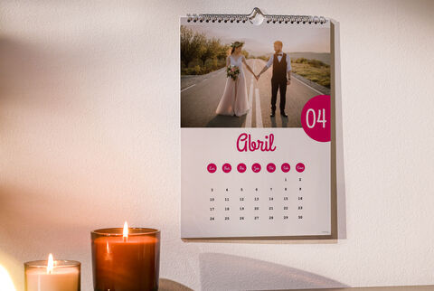 Un calendario de pared muestra a una pareja abrazándose en la calle. Detrás se ven árboles y un hermoso cielo.