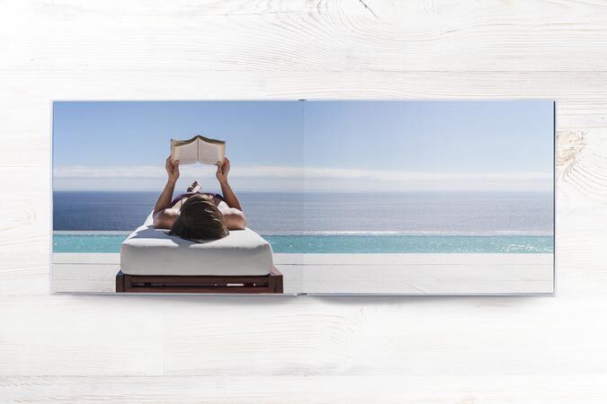 Persona relajada junto a la piscina leyendo un libro