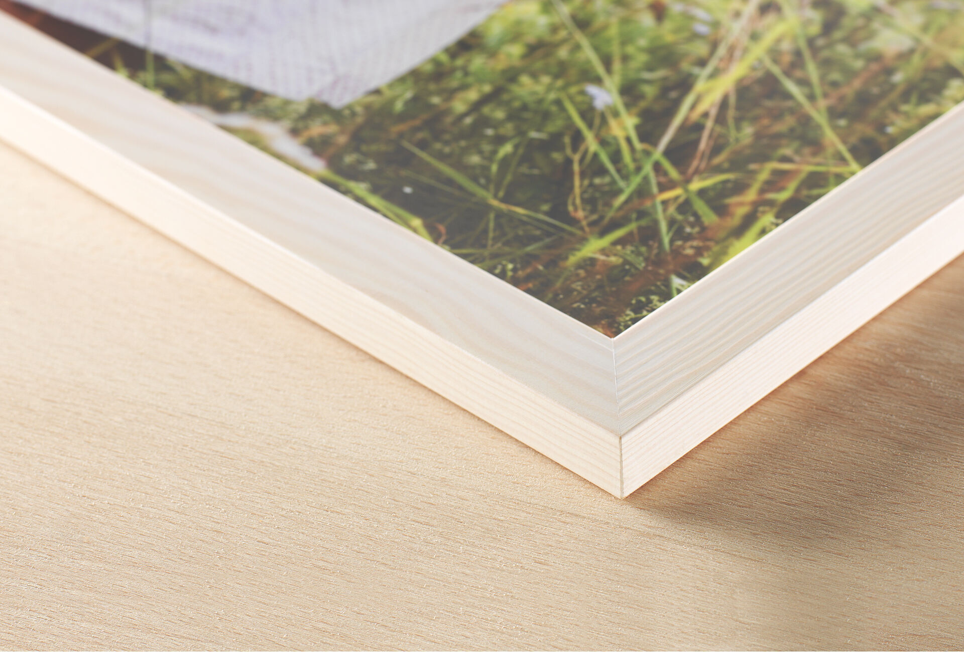Primer plano de un marco con revestimiento de madera y una hermosa impresión al fondo.