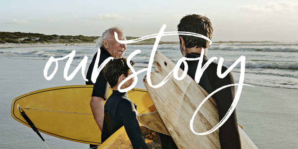 Tres personas en la playa con tablas de surf ríen y disfrutan del tiempo juntos.