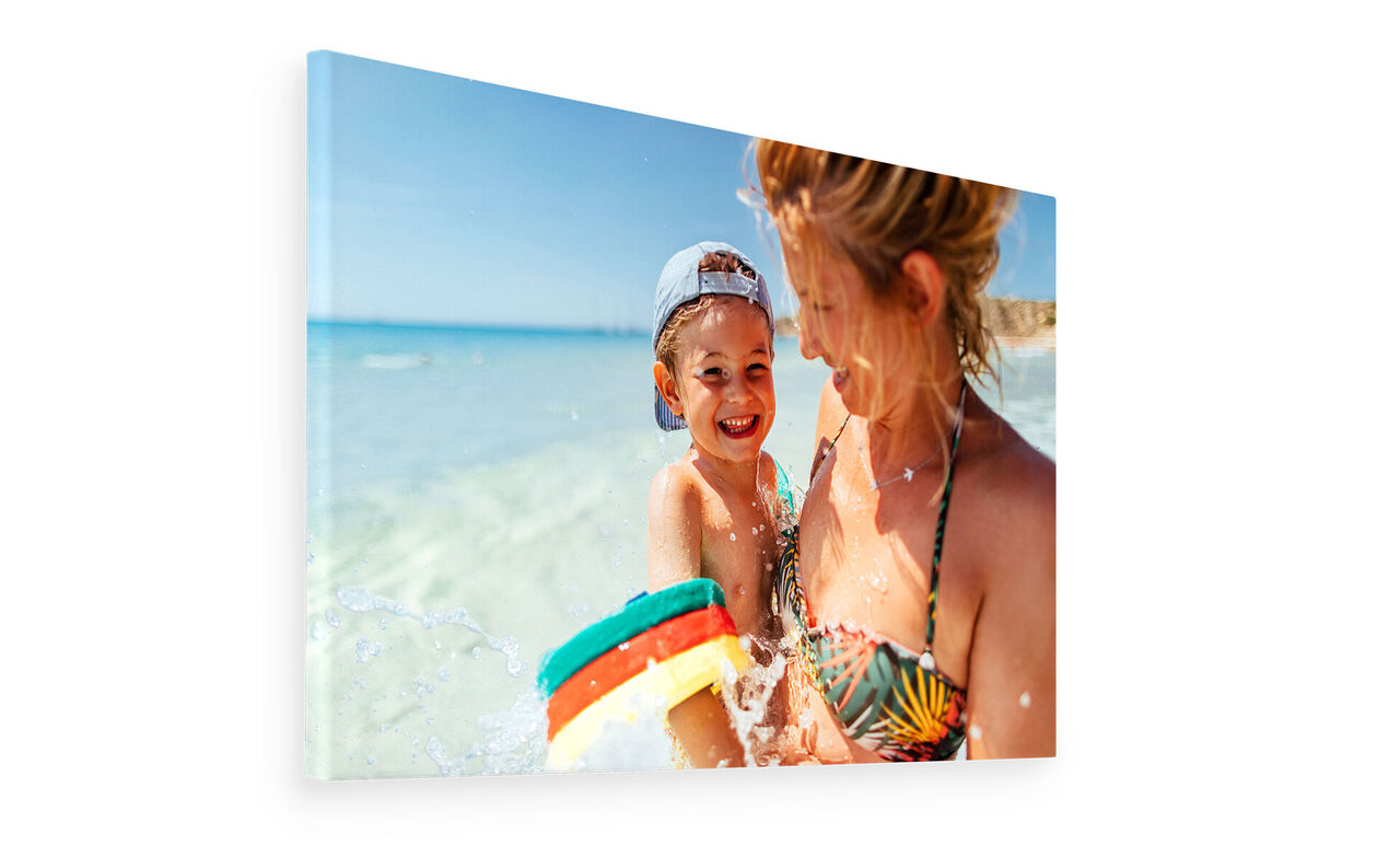 Una madre con su hijo en la playa, disfrutan del agua y el sol.