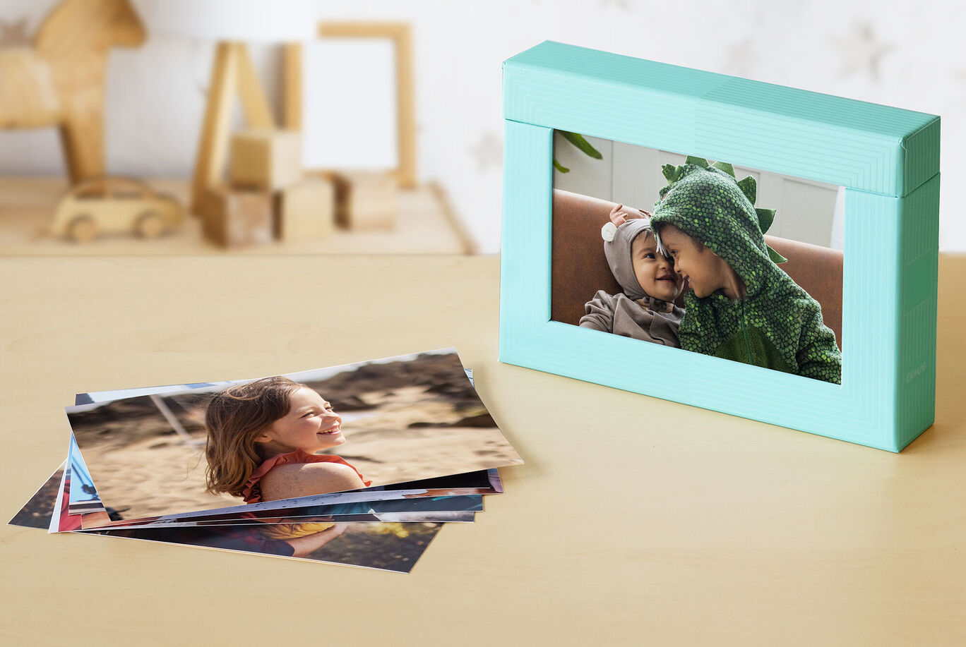 Una hermosa caja de fotos verde menta con fotos sobre una mesa.