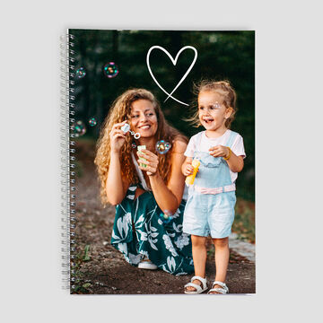 Una madre sopla burbujas con su pequeño en el exterior.