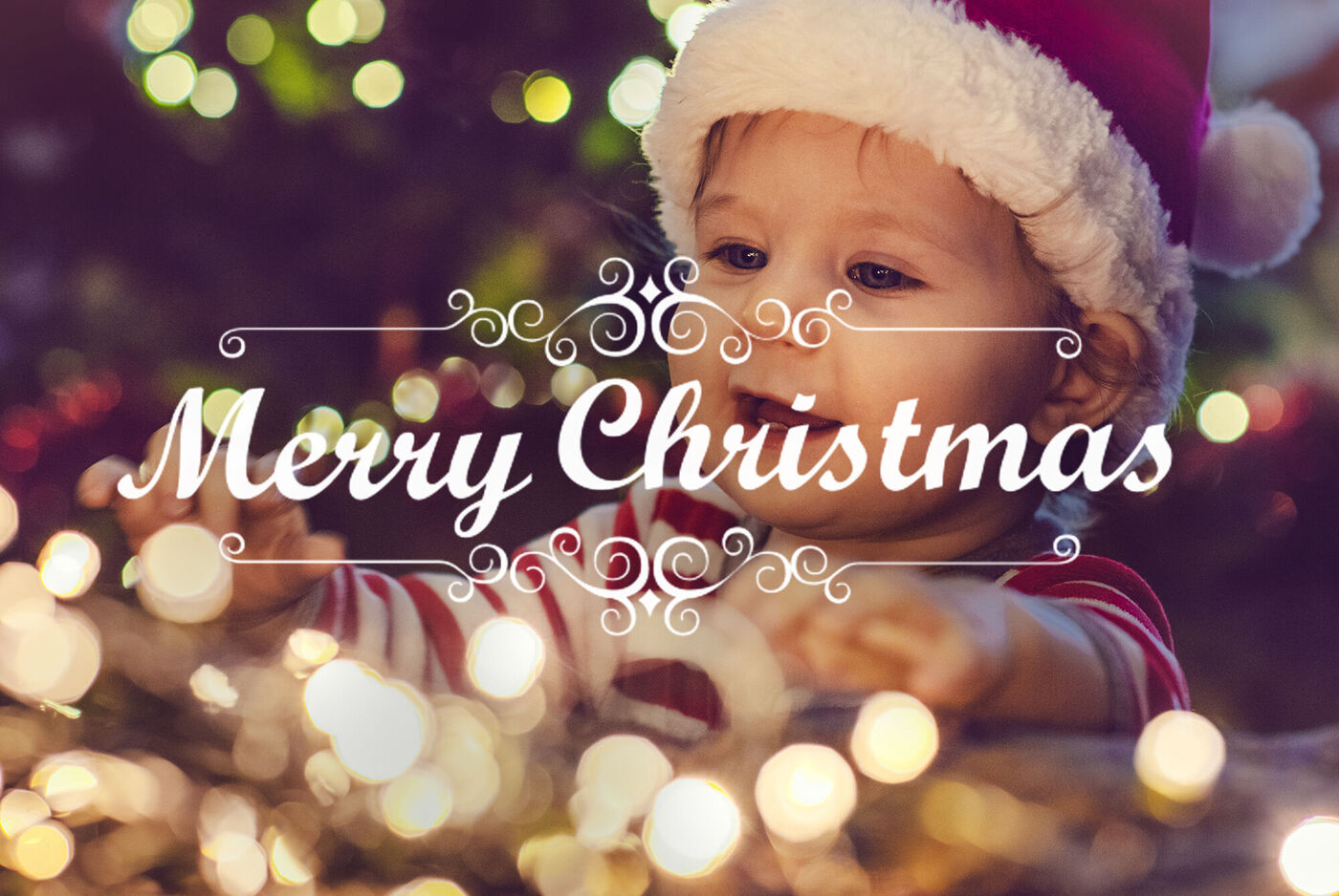 Un niño con gorro navideño juega con luces y muestra alegría.