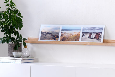 Tres fotos de paisajes de playa en un estante, resaltando recuerdos de vacaciones.