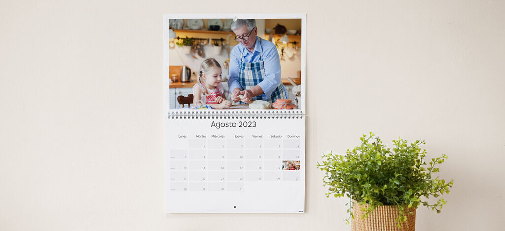 Una abuela y su nieto horneando juntos en la cocina, sonriendo y felices, en un calendario CEWE de agosto 2023.